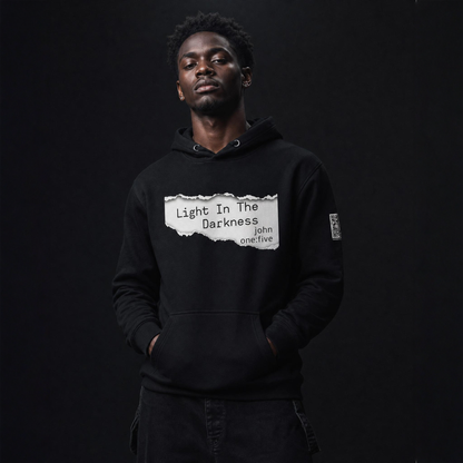 Person wearing a black hoodie with text Light In The Darkness