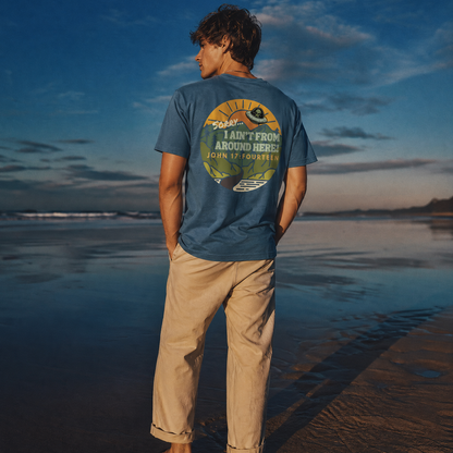 Person standing on a beach wearing a blue t-shirt with text Sorry, I Ain't From Around Here