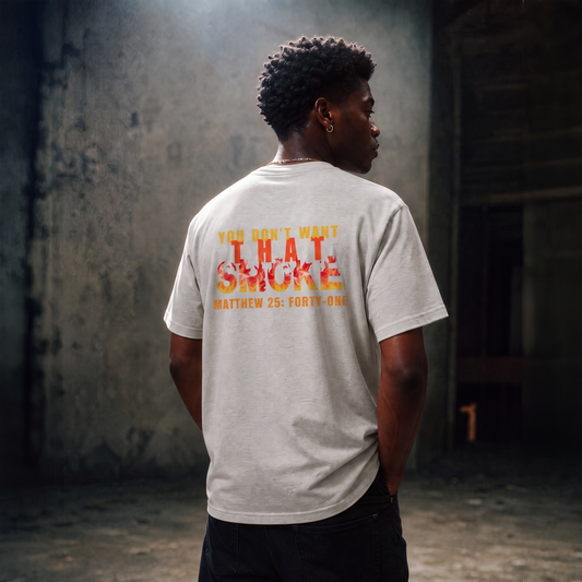 Model is wearing an ash gray t-shirt with a graphic print on the chest that reads 'YOU DON'T WANT THAT SMOKE MATTHEW 25:41' in yellow and orange flame-style lettering, posed against a gray studio background.