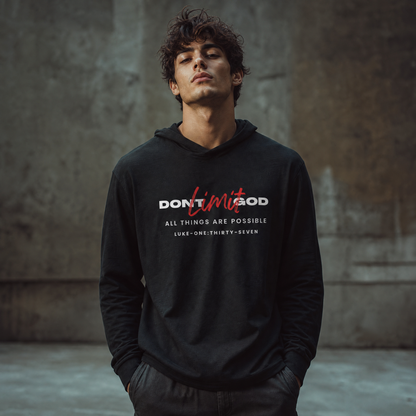 Person wearing a black hoodie with motivational text 'Don't Limit God' standing in front of a gray wall.