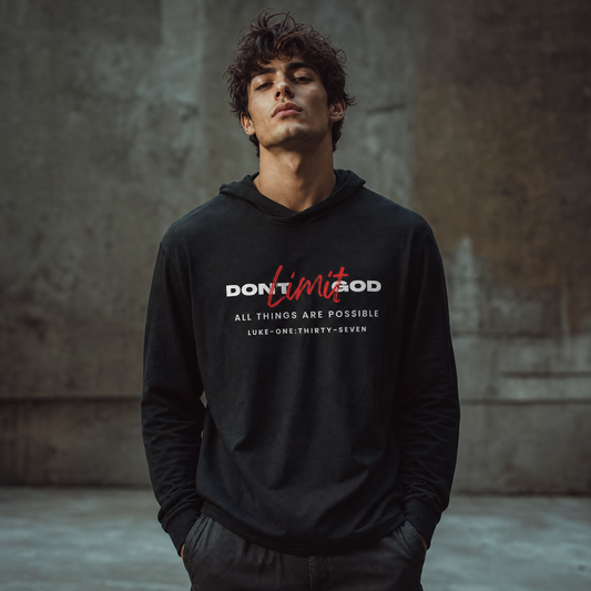 Person wearing a black hoodie with motivational text 'Don't Limit God' standing in front of a gray wall.
