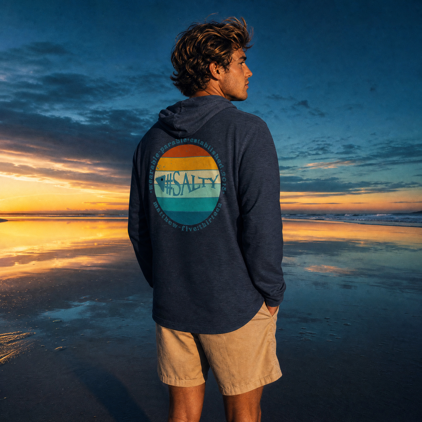 Person wearing a hoodie with a '#Salty'  on the beach at sunset