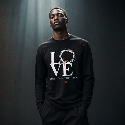 Model is wearing a black long sleeve t-shirt with text 'LOVE' and a graphic of the crown of thorns in place of the 'O' standing in front of a gray wall.