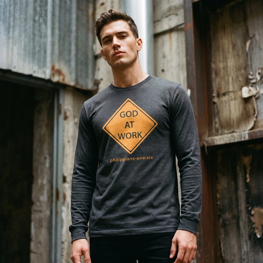 Man wearing a long-sleeve t-shirt with 'GOD AT WORK' text in an industrial setting