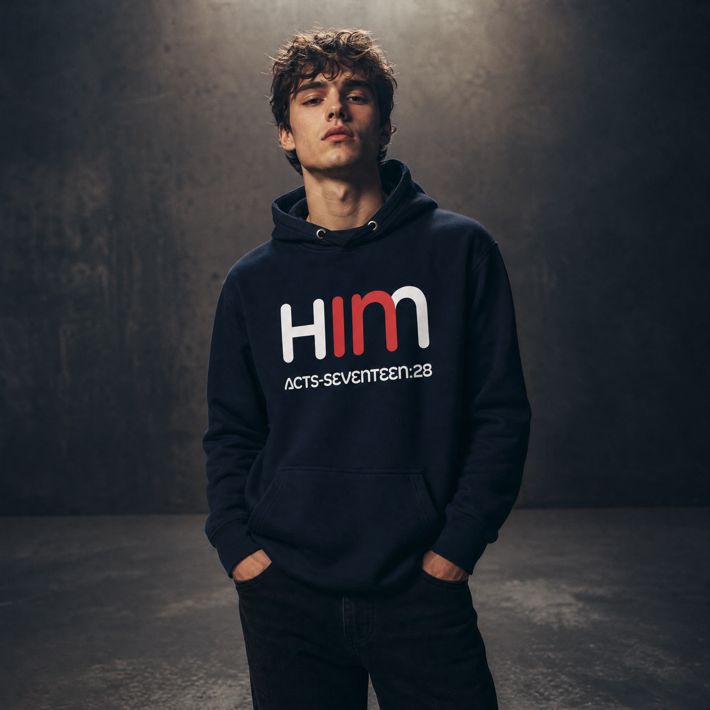 Person wearing a dark hoodie with 'IN HIM' text on a dark background