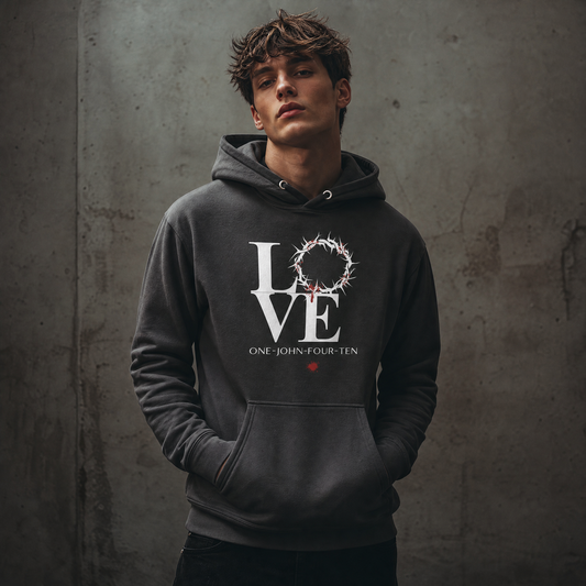 Model is wearing a vintage black hoodie with text 'LOVE' and a graphic of the crown of thorns in place of the 'O' standing against a gray wall.