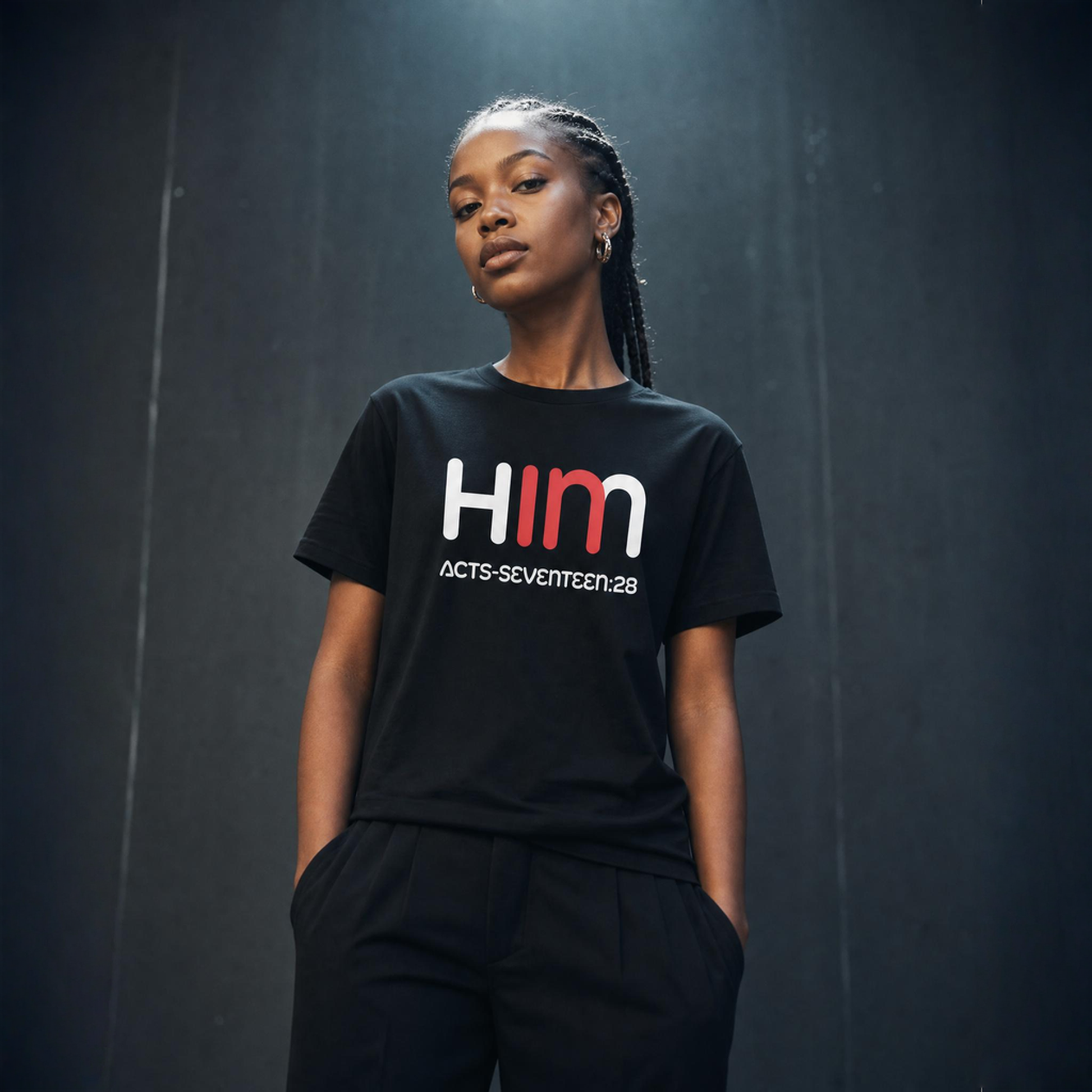 Person wearing a black t-shirt with 'IN HIM' text against a dark background