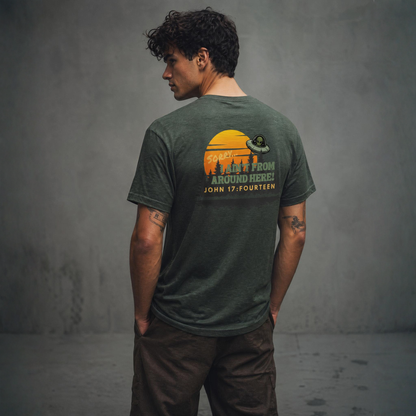Model wearing a heather forest green t-shirt with graphic and text 'Sorry, I Ain't From Around Here' standing next to a concrete wall