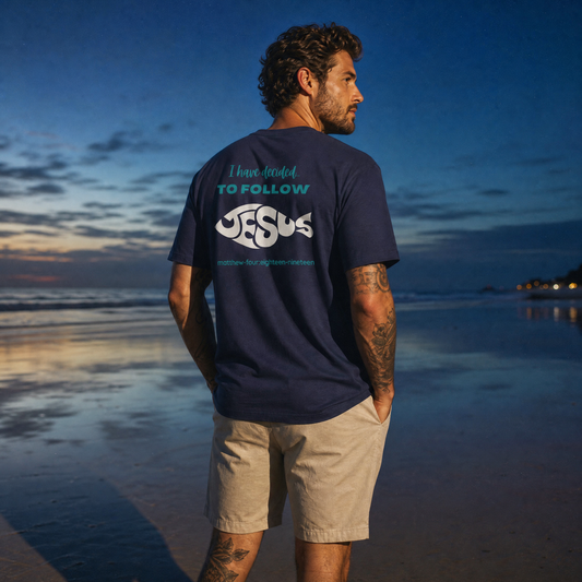 Person wearing a navy blue t-shirt with 'I have decided to follow Jesus' text on the beach at sunset.