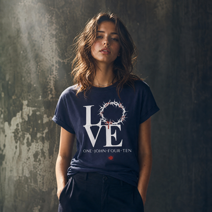 Model is wearing a navy blue t-shirt with text 'LOVE' and a graphic of the crown of thorns in place of the 'O' standing in front of a gray wall.