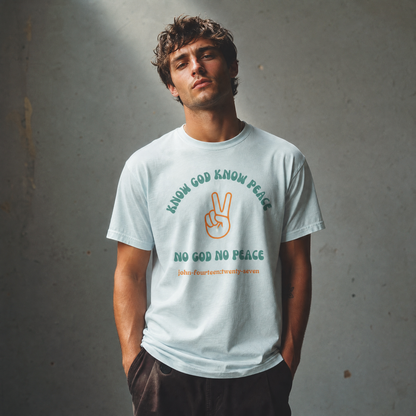Man wearing a light blue t-shirt with text 'Know God Know Peace, No God No Peace' with a peace symbol standing against a textured wall background