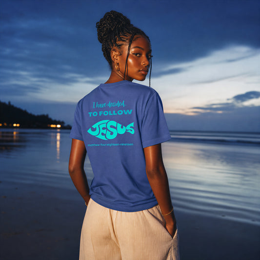 Person wearing an 'I Have Decided To Follow Jesus' blue t-shirt standing on a beach shore.