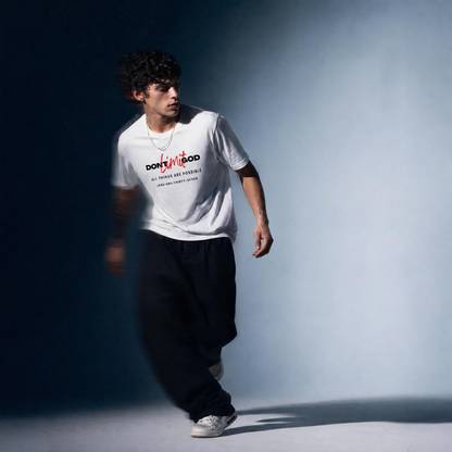 Person wearing a white t-shirt with text 'Don't Limit God' and dark pants against a gradient background