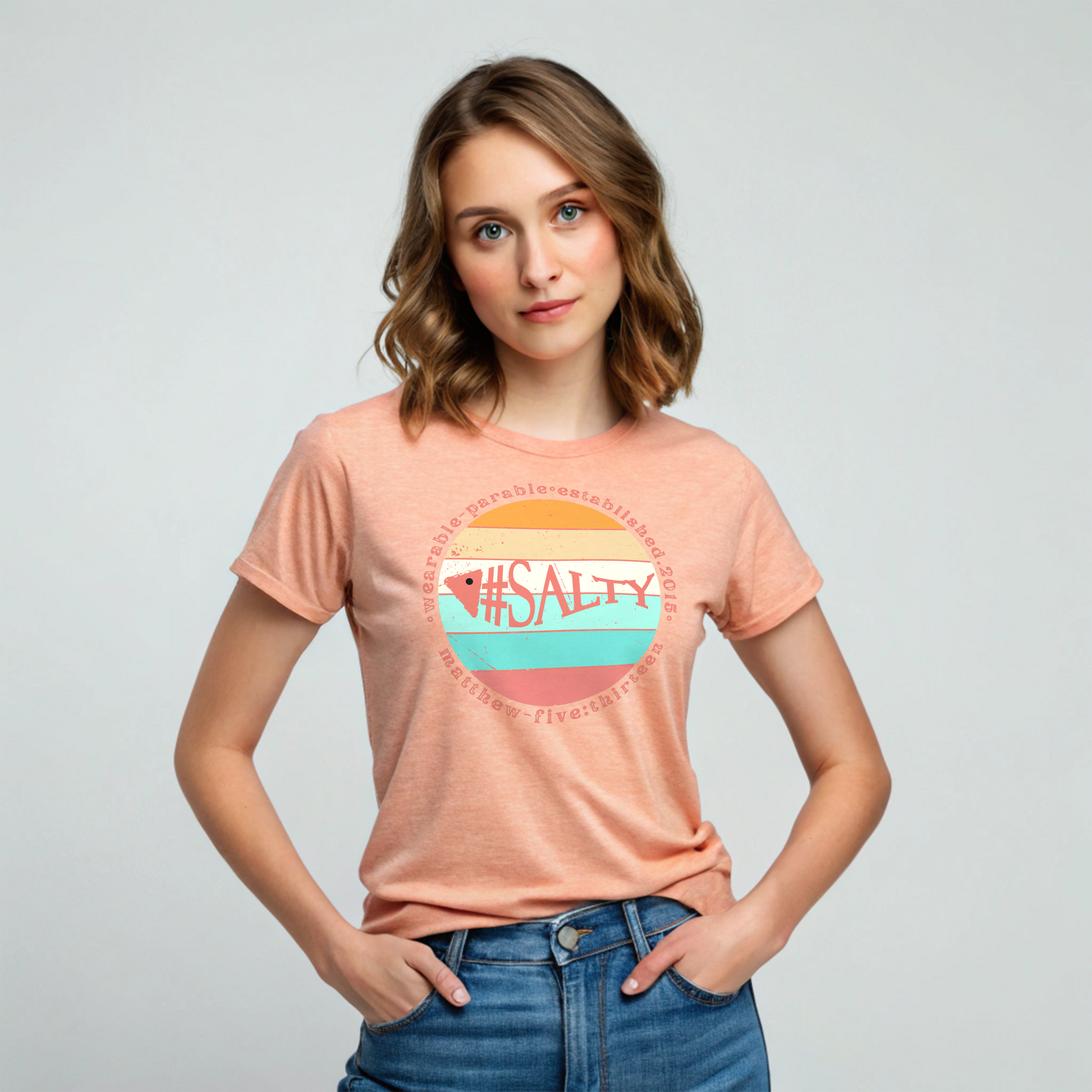 Woman wearing a peach t-shirt with '#SALTY' design on a plain background