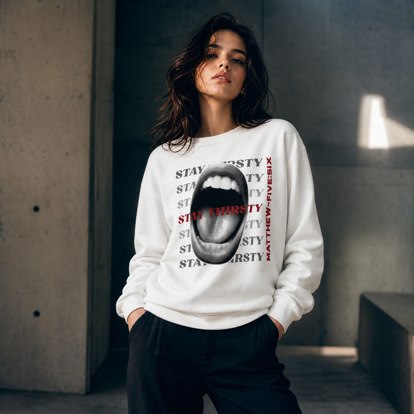 Person wearing a white sweatshirt with text Stay Thirsty and graphic of a wide open mouth.