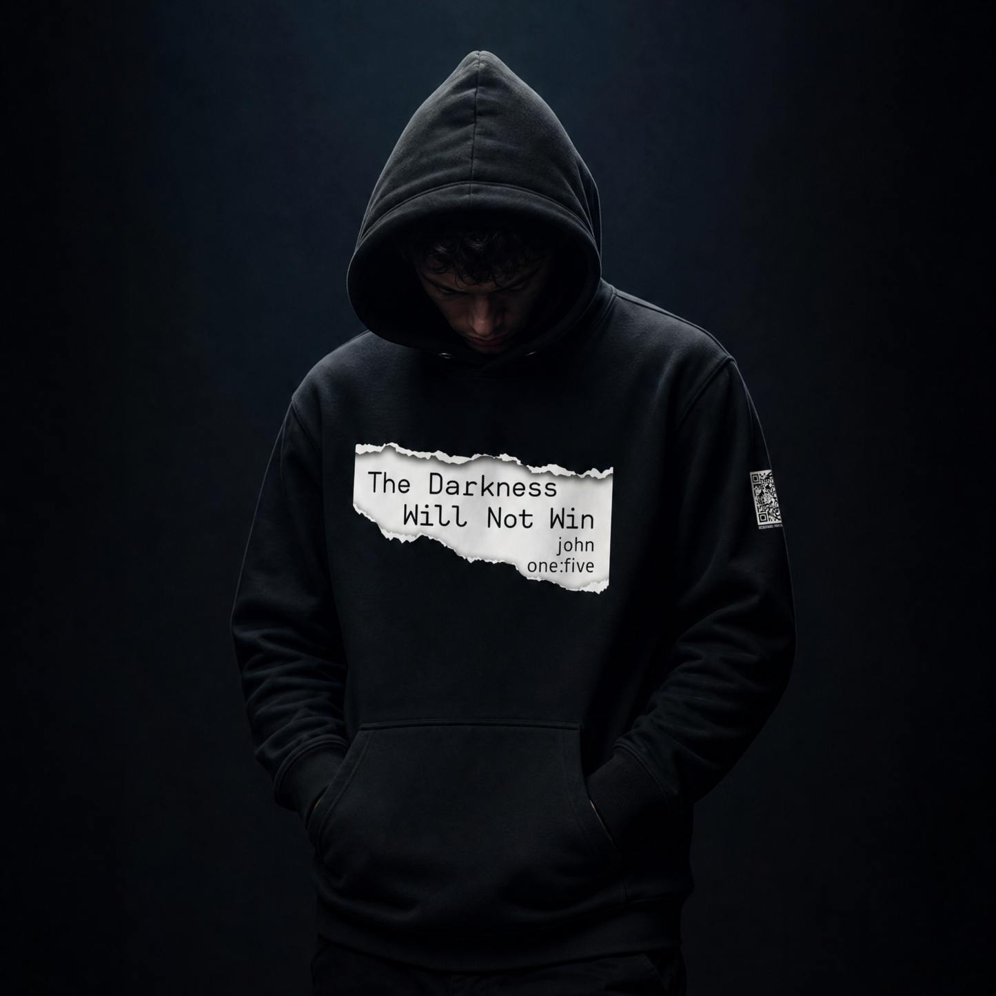 Person wearing a black hoodie with text The Darkness Will Not Win