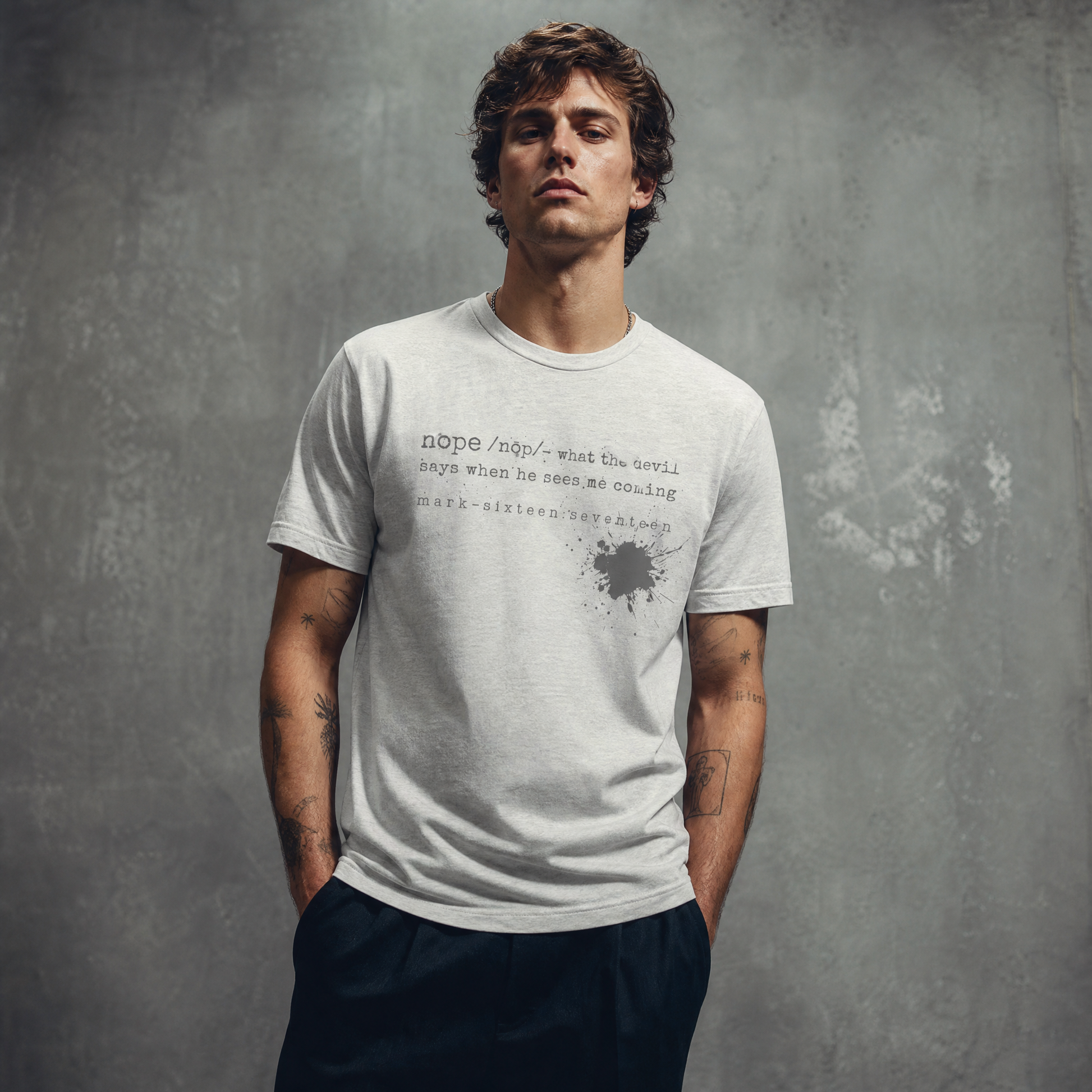 Man wearing a white t-shirt with text and splatter design on a gray background